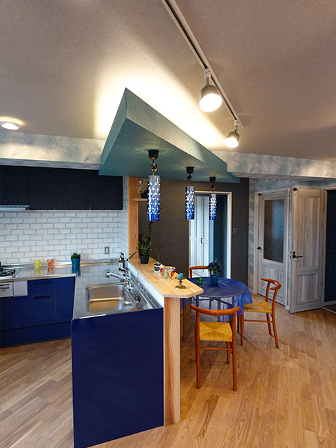 L型のキッチンは下がブルーで吊戸棚は黒の木目にしました